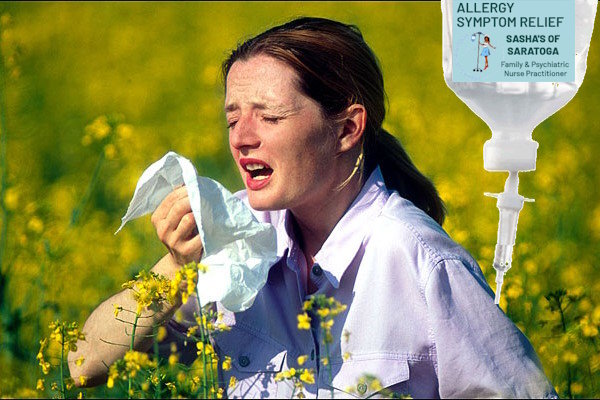 Woman sneezing in field of flowers, IV bag in foreground.